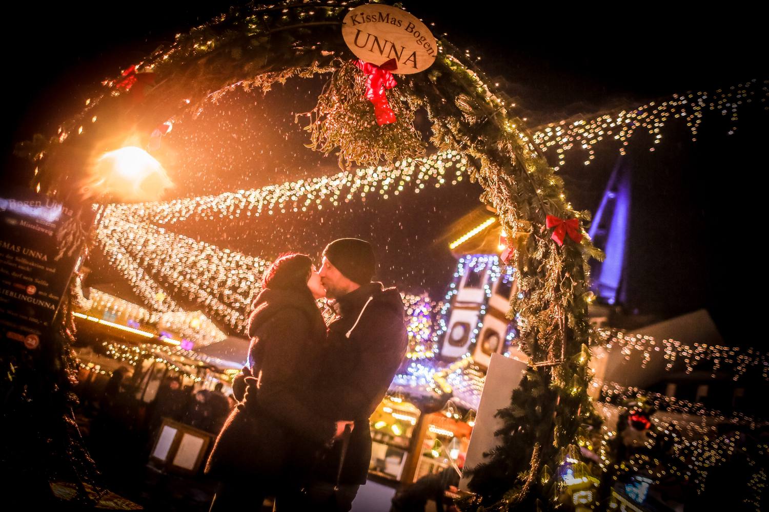 Paar küsst sich unter dem Kissmas-Bogen
